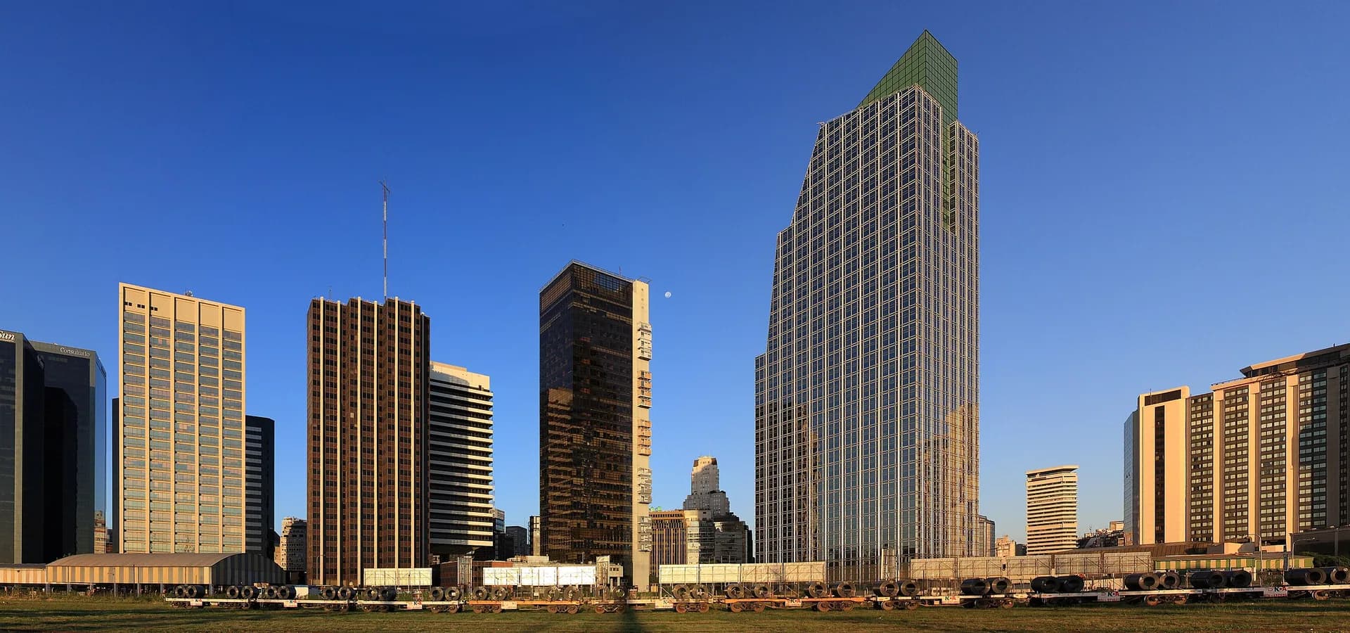 Panorama de torres de escritórios do centro de Buenos Aires sob a luz quente da tarde e um céu azul limpo.
