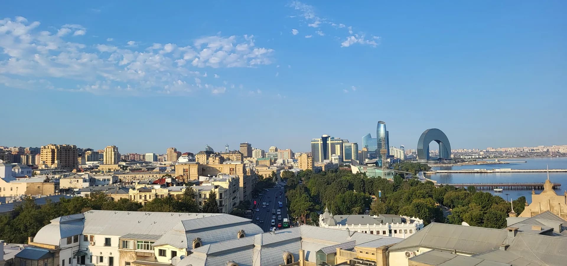 Rooftops of central Baku seen from the Maiden Tower, with seafront high-rises and the Caspian bay under a blue sky