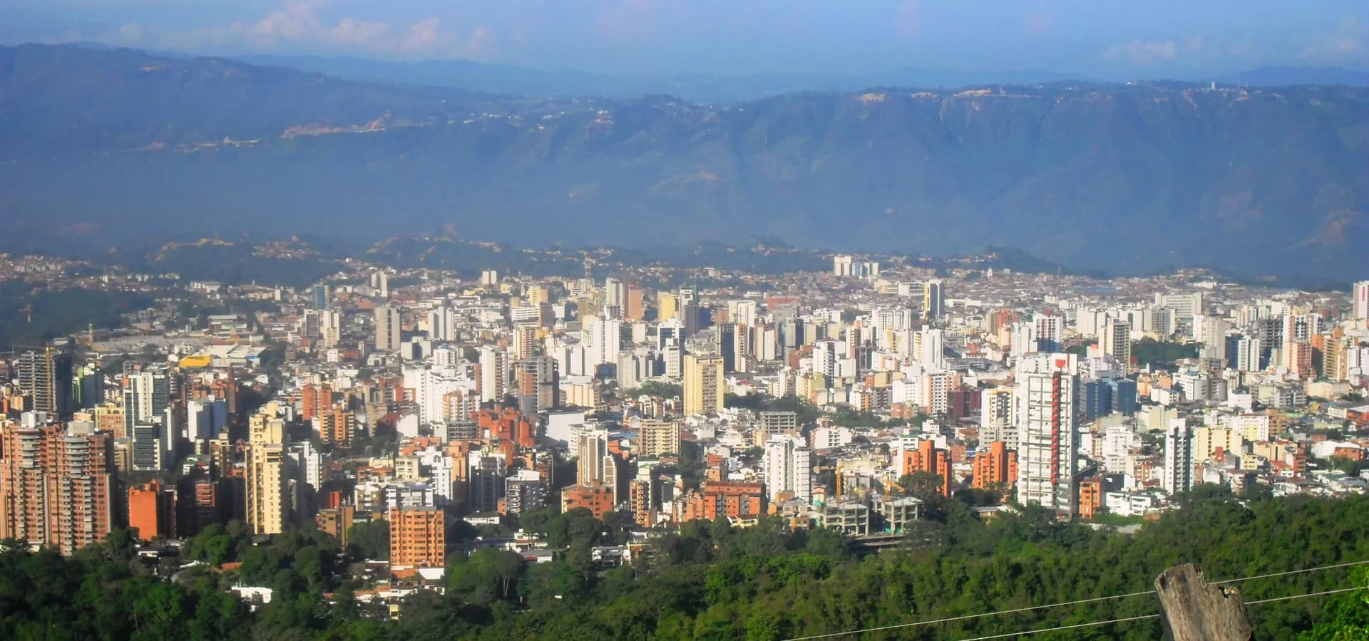 Wide view of Bucaramanga's towers spread across a plateau below long blue mountain ridges