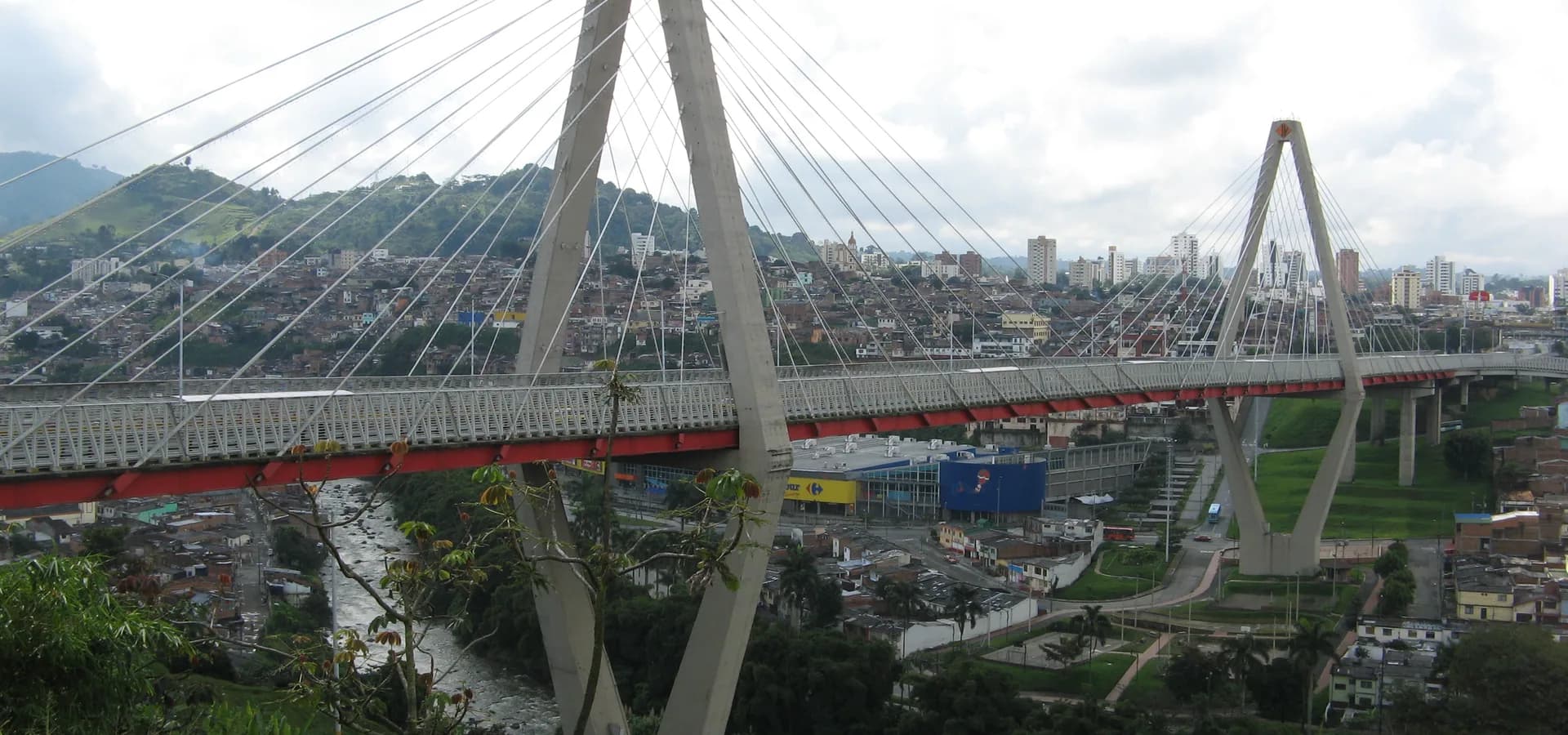 Ponte estaiada sobre o vale do rio Otún, com os bairros de encosta e as torres de Pereira ao fundo