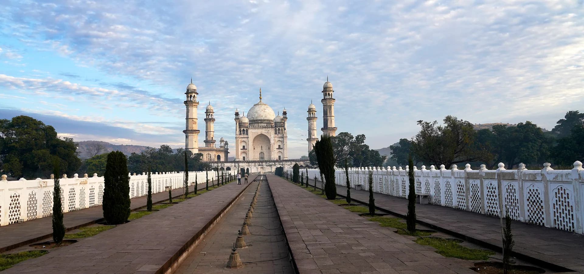 बीबी का मकबरा तक जाता लंबा बाग का रास्ता और जल नहर, पीछे पहाड़ियां और सुबह का खुला आसमान