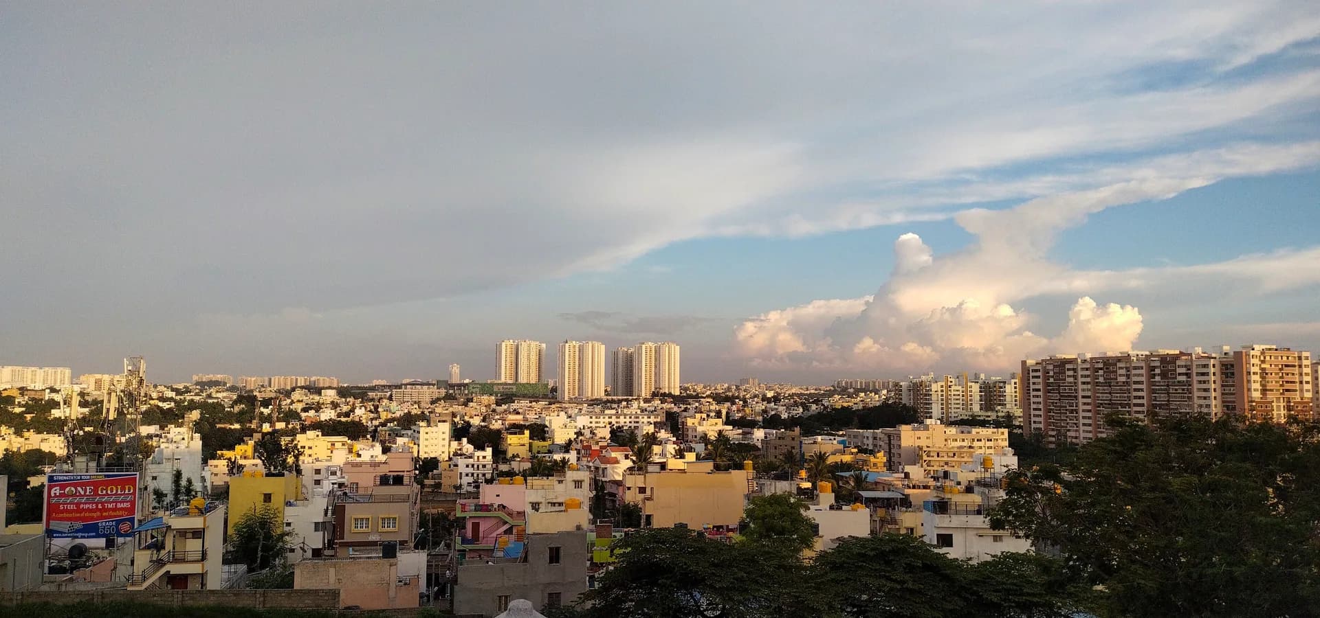 Azoteas y torres de apartamentos del sur de Bengaluru que se extienden hasta el horizonte bajo nubes suaves y cielo azul