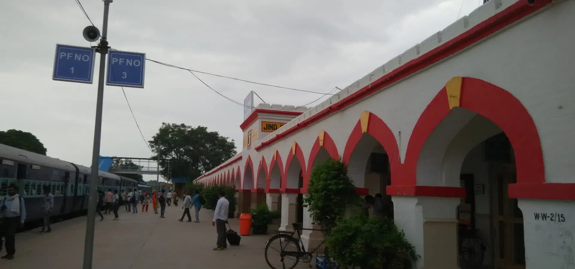 Rot eingefasste weiße Bögen am Bahnsteig des Bahnhofs Jind Junction unter bewölktem Himmel