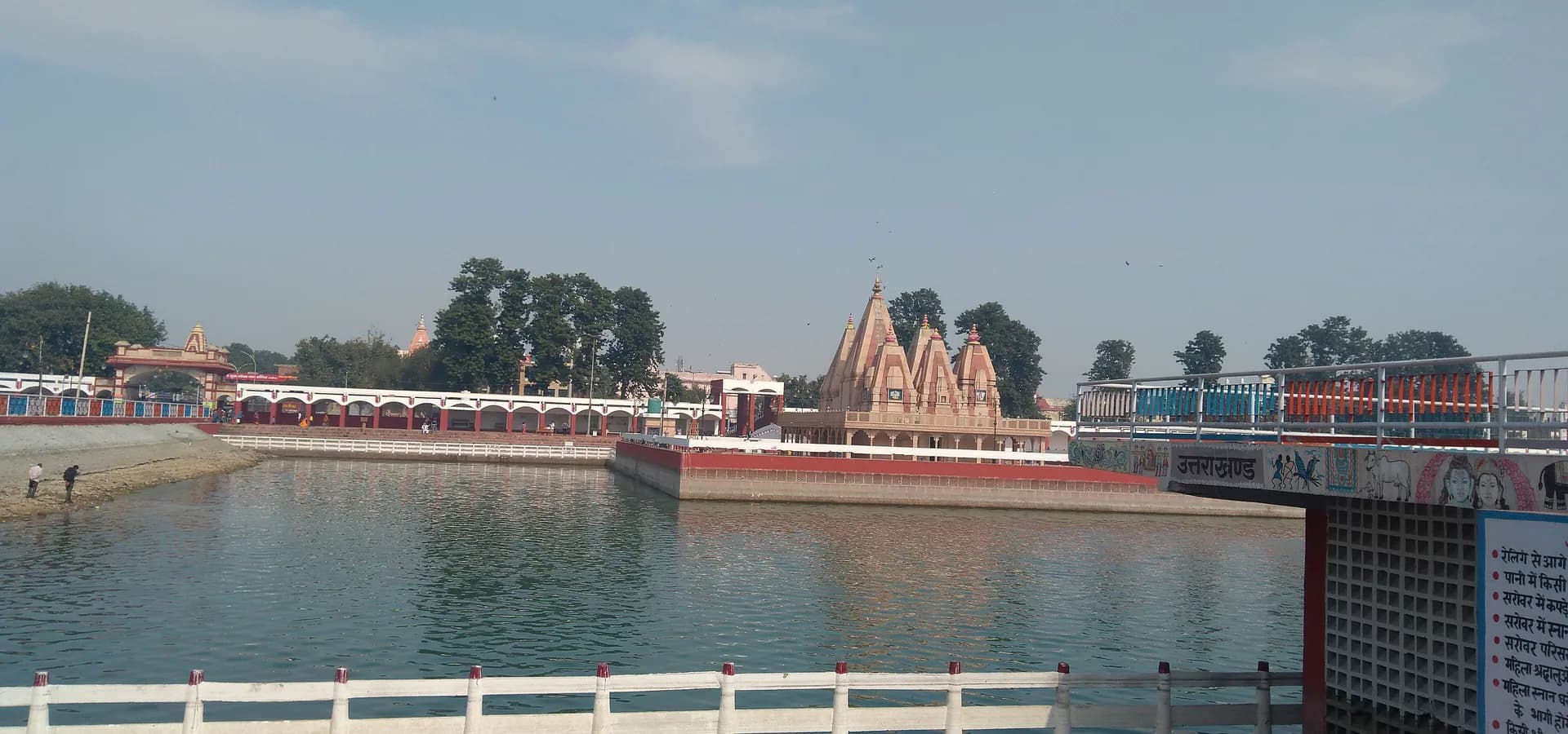 Vista amplia sobre el agua de Brahma Sarovar hacia su templo en la isla y los ghats con arcadas en Kurukshetra