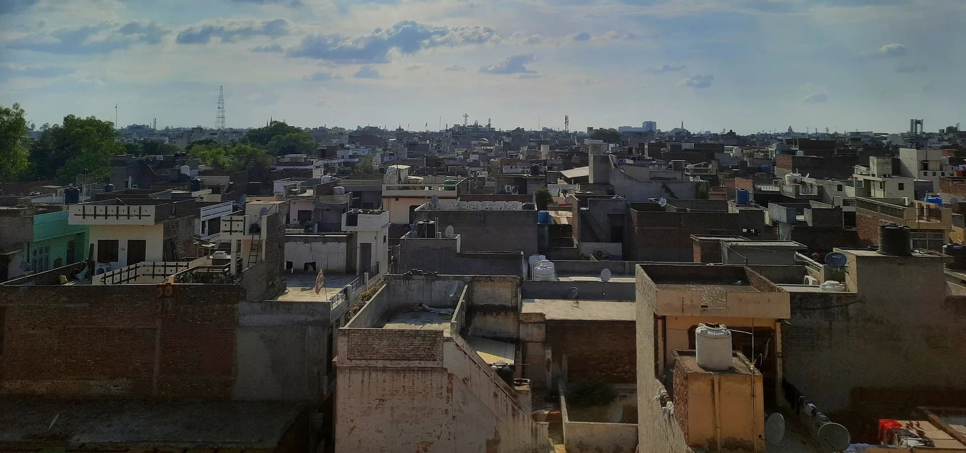 Flache Dächer von Ludhiana bis zum Horizont unter weitem blauem Himmel mit zarten Wolken