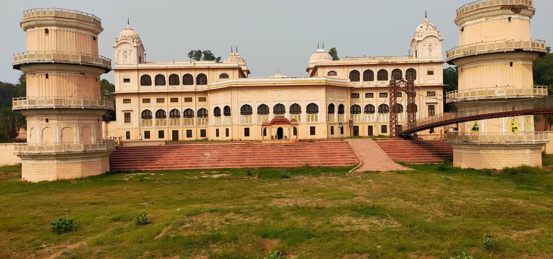 Der cremefarbene Sheesh Mahal in Patiala, eingerahmt von zwei runden Türmen und einer Hängebrücke