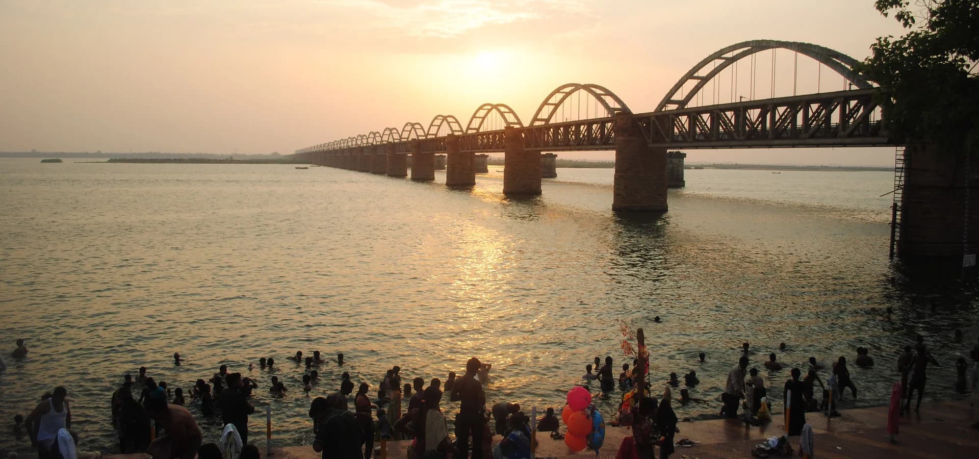Atardecer dorado sobre el ancho río Godavari y los arcos del puente Godavari Arch en Rajahmundry