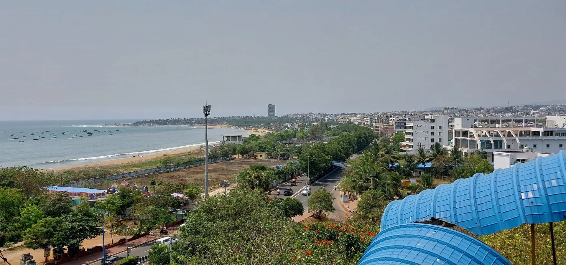 Visakhapatnam vista desde el teleférico de Kailasagiri, con una playa curva y barcas de pesca a la izquierda y manzanas de la ciudad a la derecha