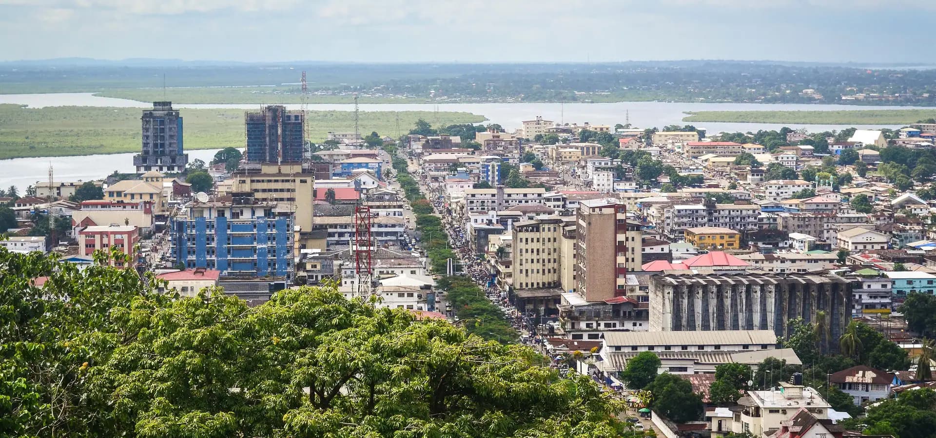 Downtown Monrovia seen from above, with Broad Street, tall buildings and the Mesurado River wetlands beyond