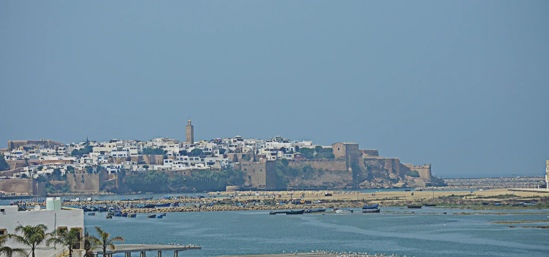 The walled Kasbah of the Udayas and white houses of Rabat above the Bou Regreg river mouth, with boats in the water