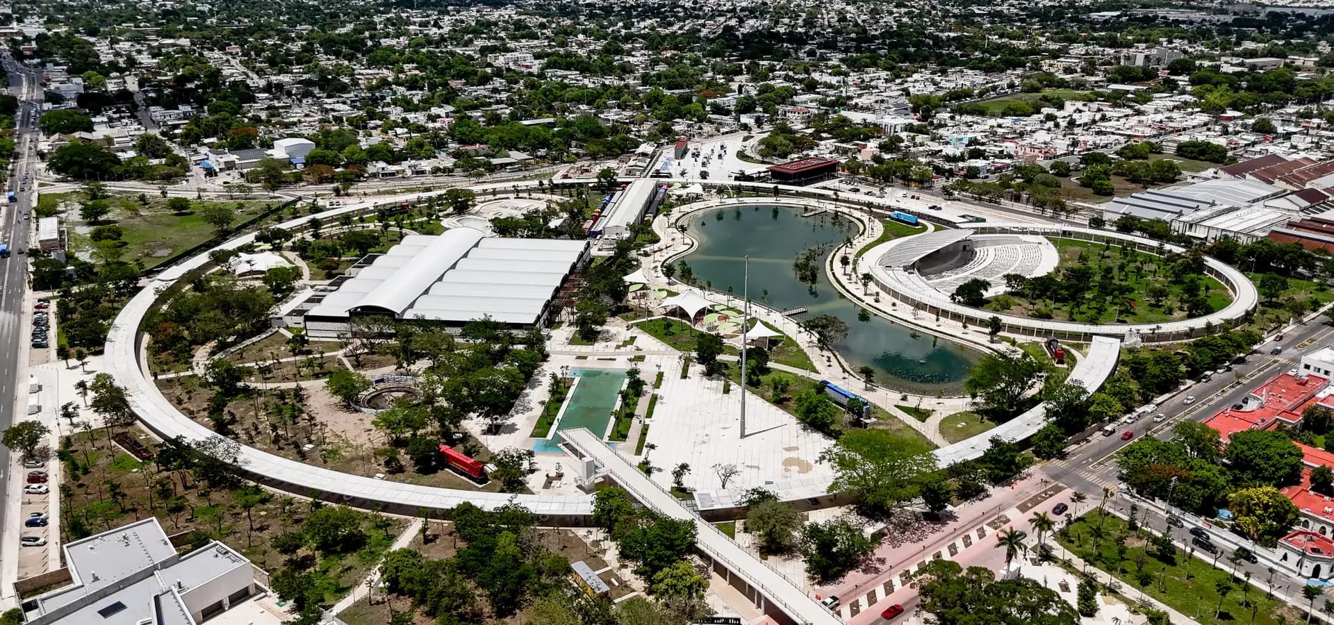 Vista aérea del Parque La Plancha, con su lago y su sendero curvo, y la plana y verde Mérida hasta el horizonte