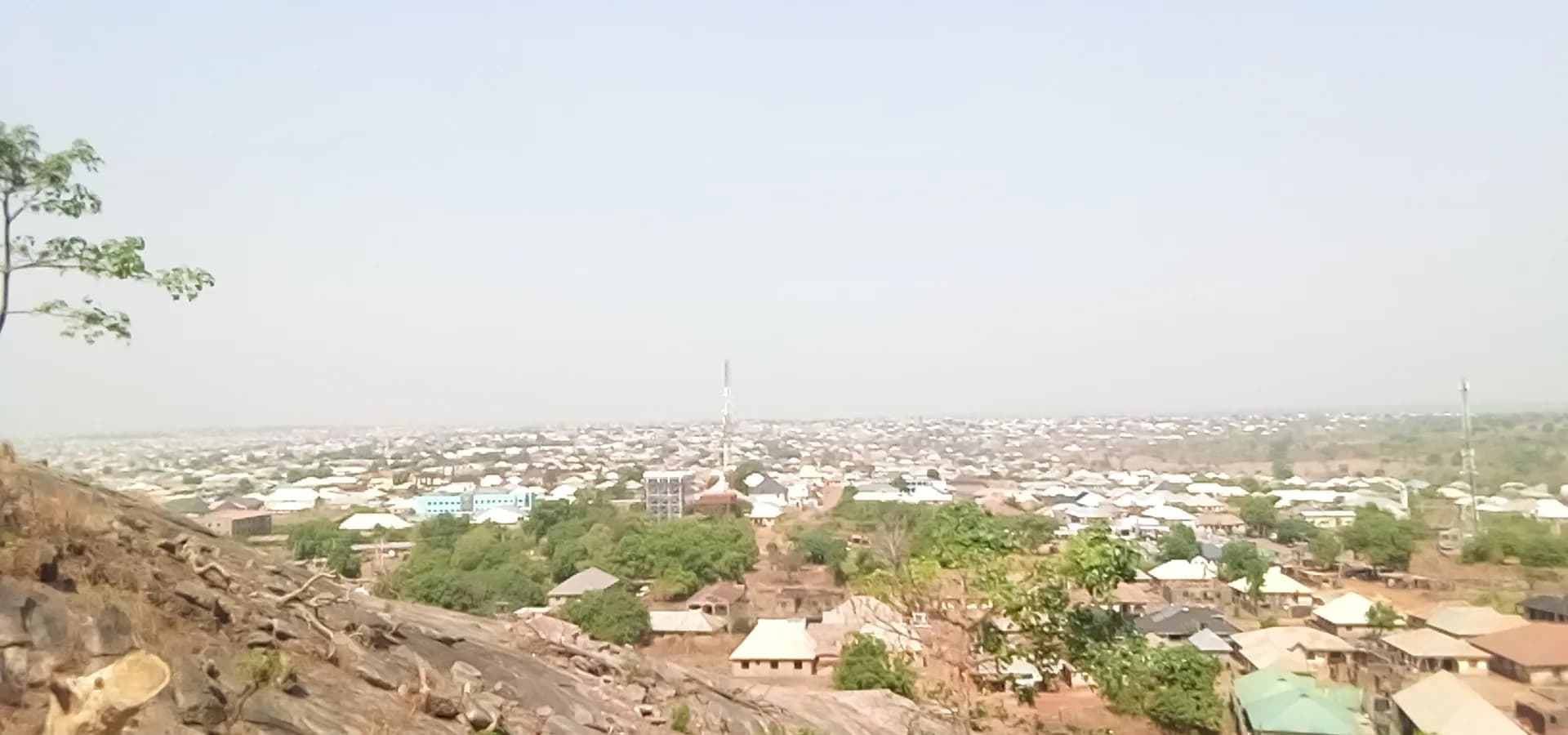 Ilorin rooftops spreading to a hazy horizon, seen from the granite slopes of Sobi Hill