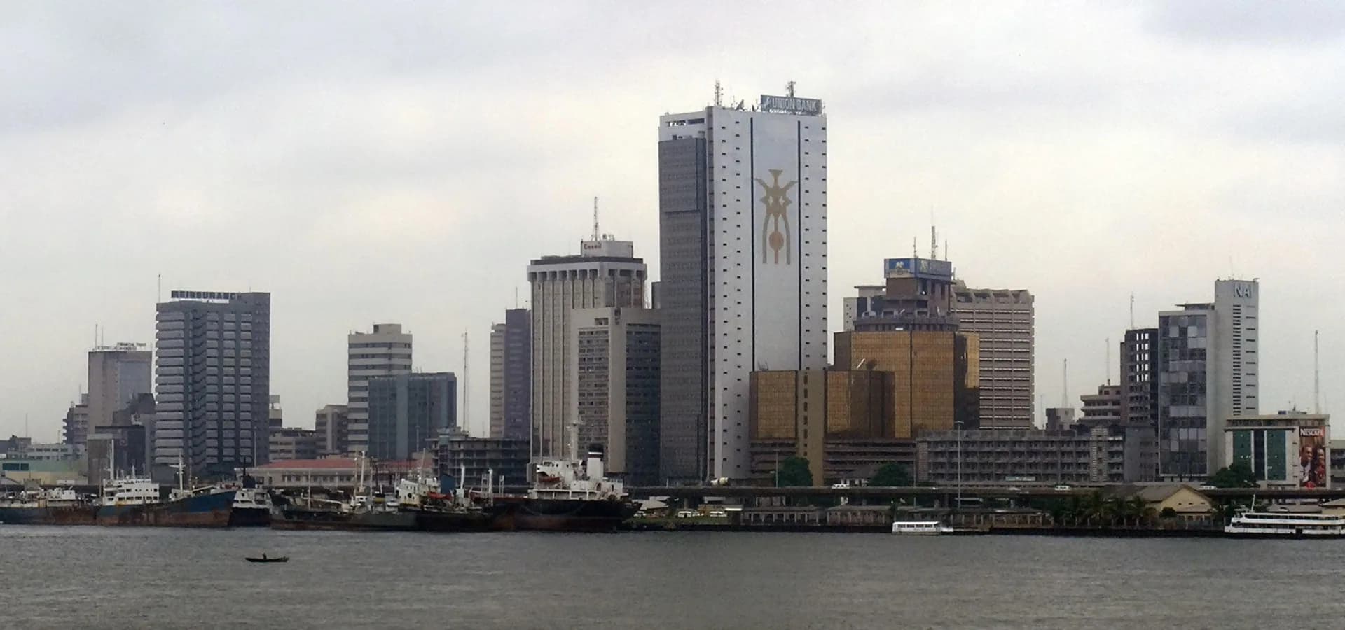 Panorama do skyline da Marina da ilha de Lagos sobre as águas calmas da lagoa sob um céu pálido em Lagos