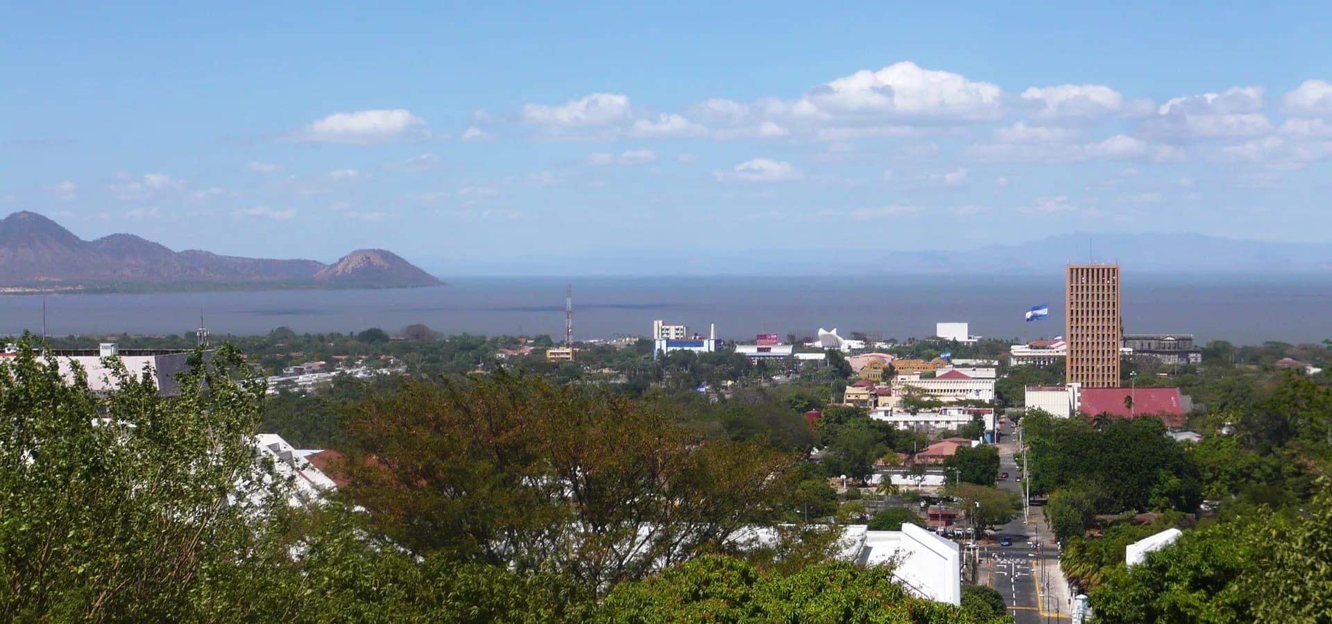 Blick von der Loma de Tiscapa über das grüne Managua zum blauen Wasser des Managuasees und zu Vulkanhügeln