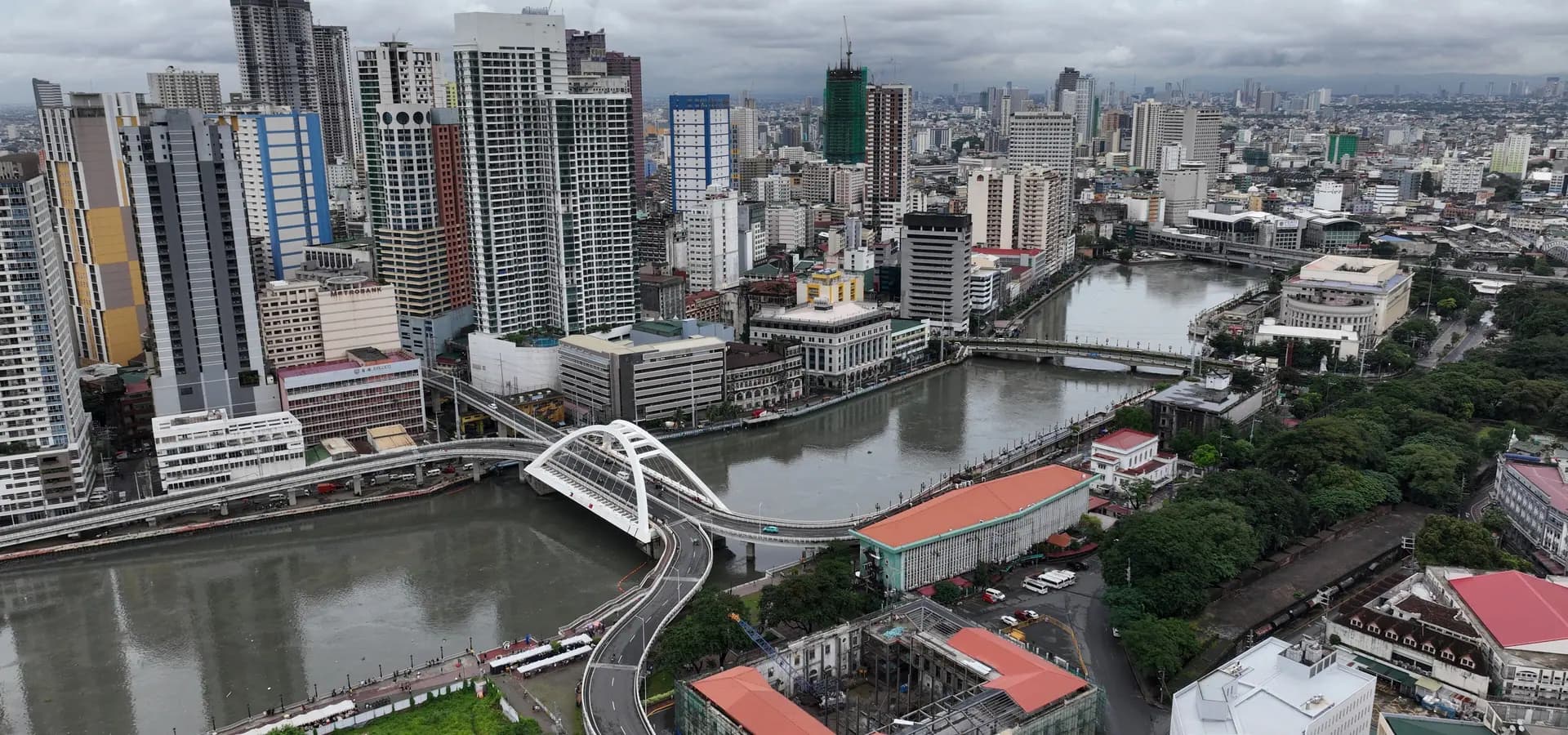 Aerial view of the Pasig River curving past the arched Binondo-Intramuros Bridge and the towers of Binondo