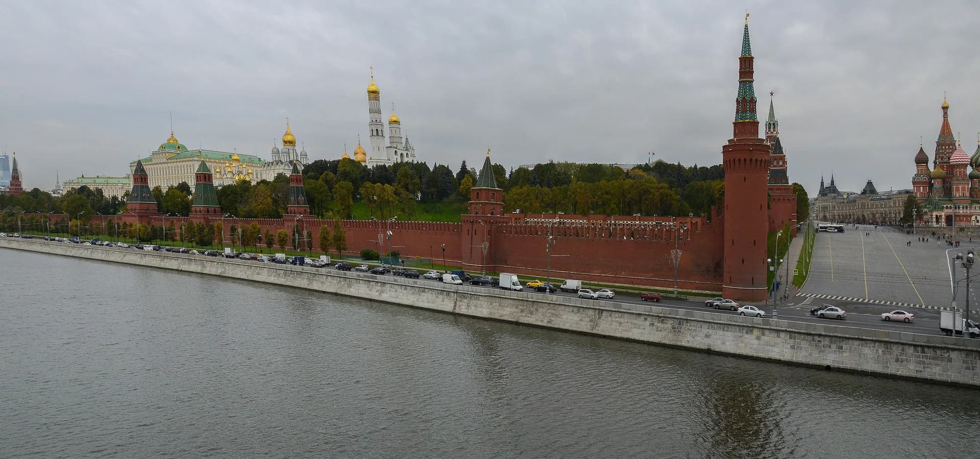 Panorama of the red Kremlin walls, golden cathedral domes and St. Basil's Cathedral seen across the Moskva River