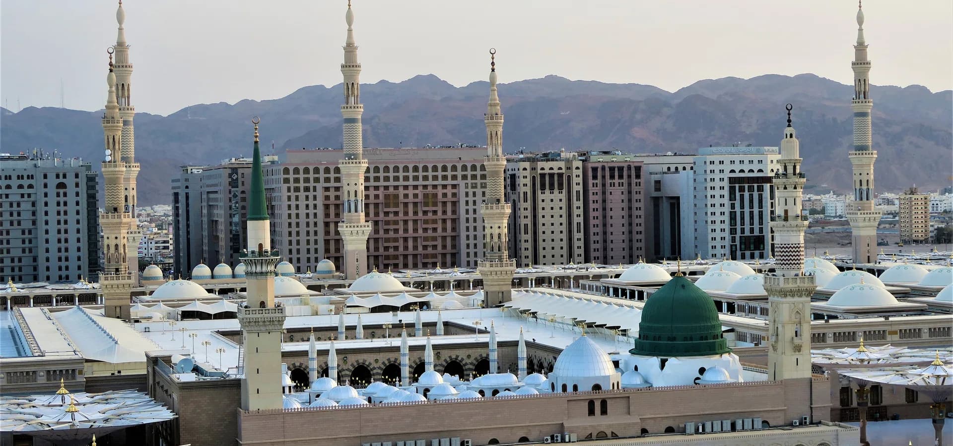 La Mezquita del Profeta en Medina vista desde arriba, con su Cúpula Verde y altos minaretes frente a colinas áridas