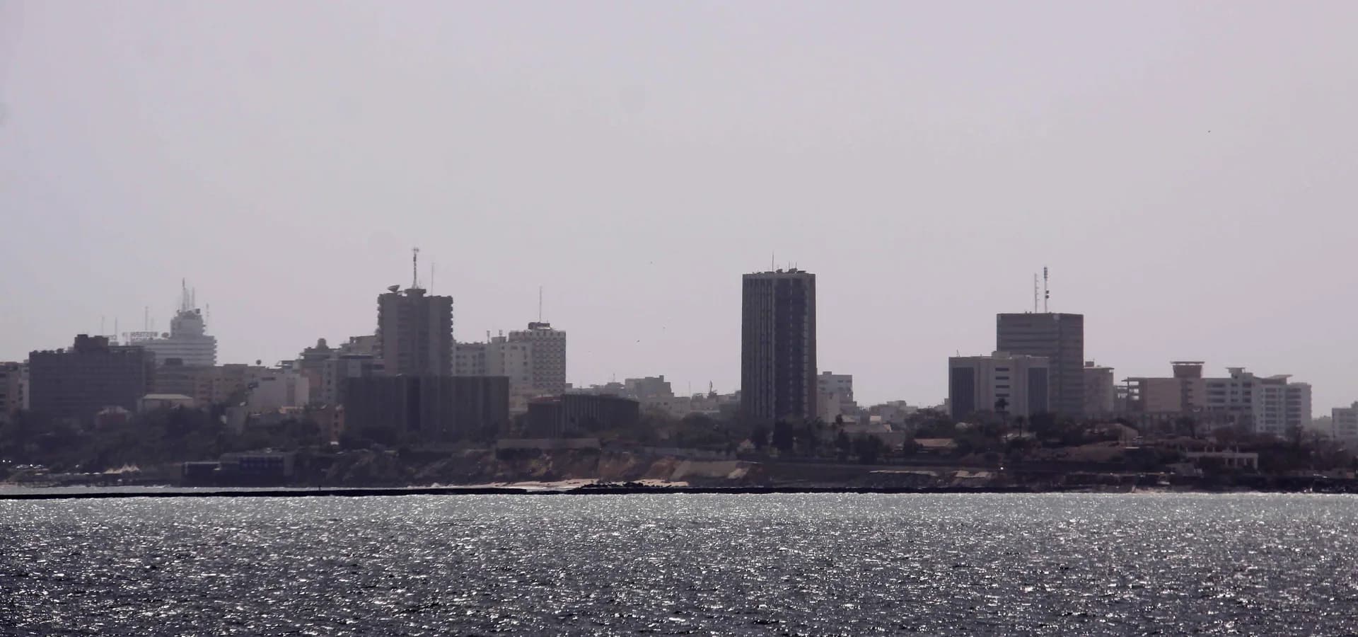 Las torres del centro de Dakar al fondo de un amplio mar reluciente, vistas desde la isla de Gorée
