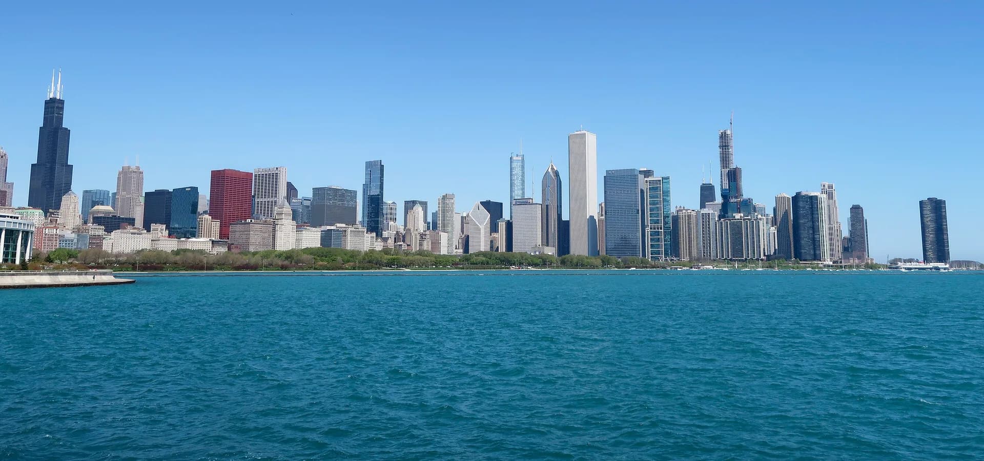 Chicago skyline with Willis Tower rising across the blue water of Lake Michigan under a clear sky
