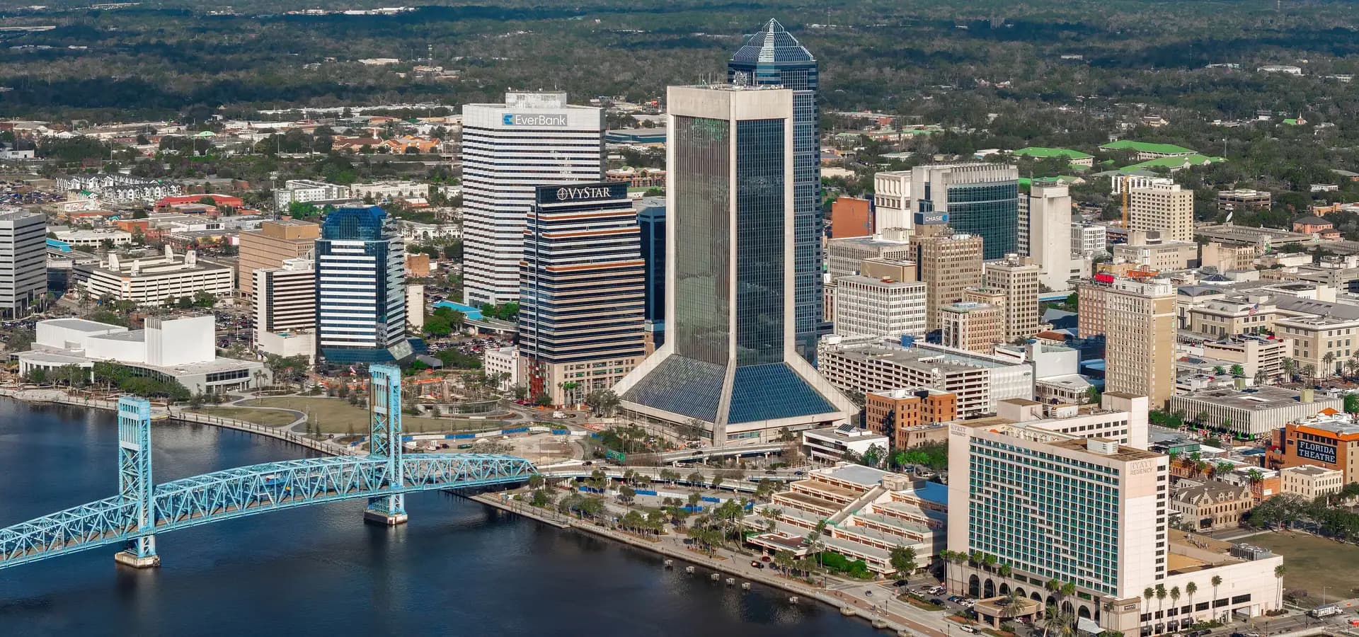 Luftbild der Innenstadt von Jacksonville, Glastürme und palmengesäumte Uferpromenade neben der blauen Main Street Bridge