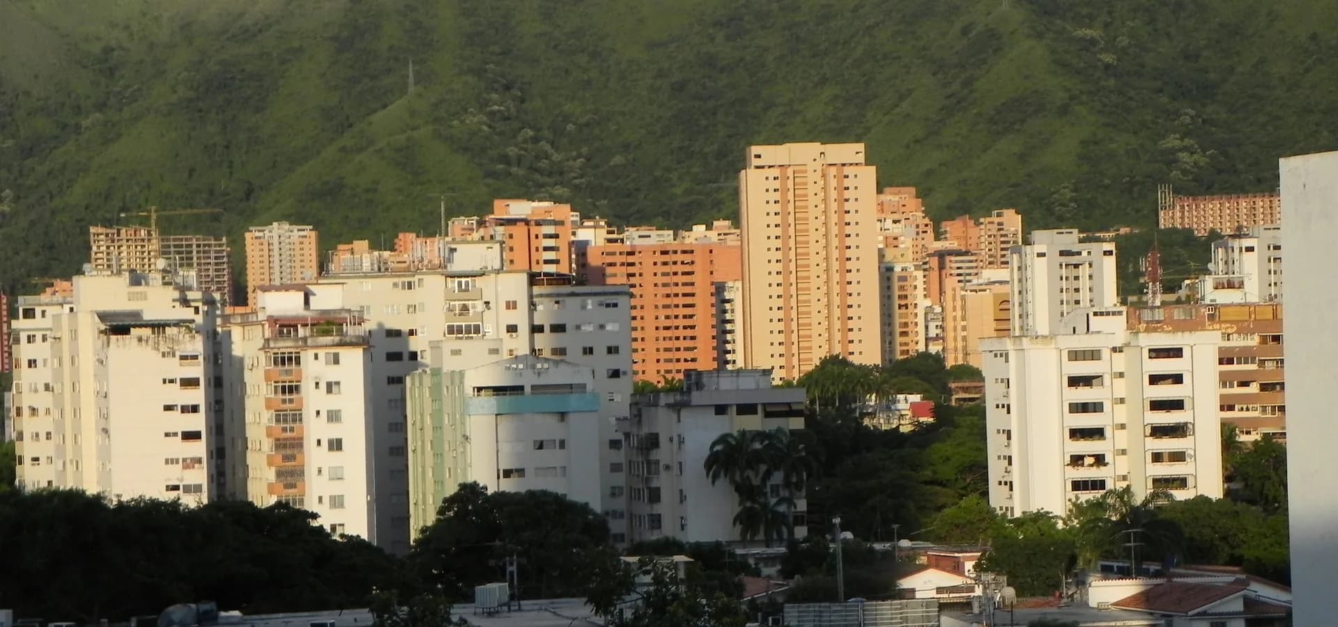 Torres de apartamentos de La Trigaleña brilhando na luz do fim de tarde contra as colinas verdes do norte de Valência