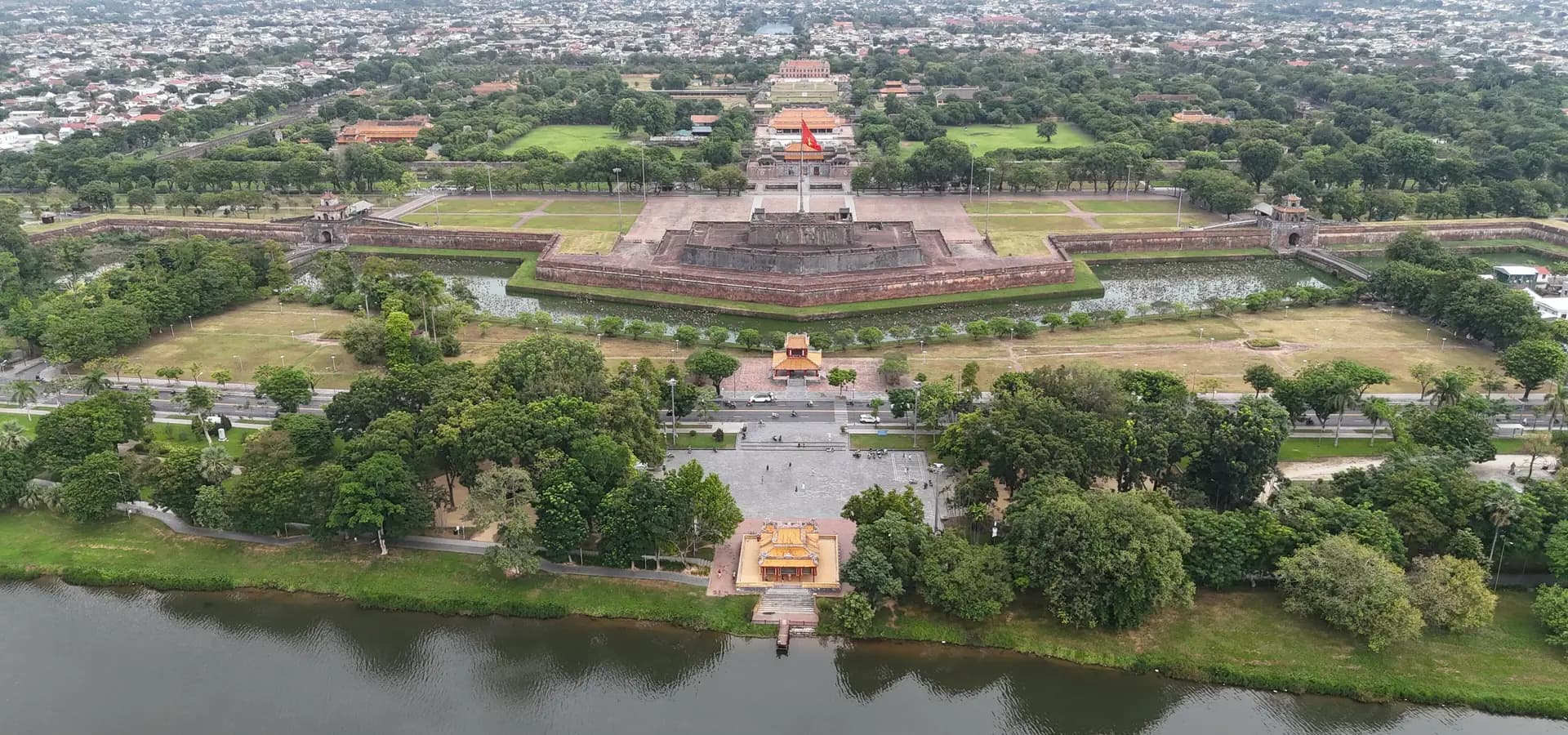 Vista aérea de la ciudadela amurallada de Huế y su torre de la bandera, con el río de los Perfumes en primer plano