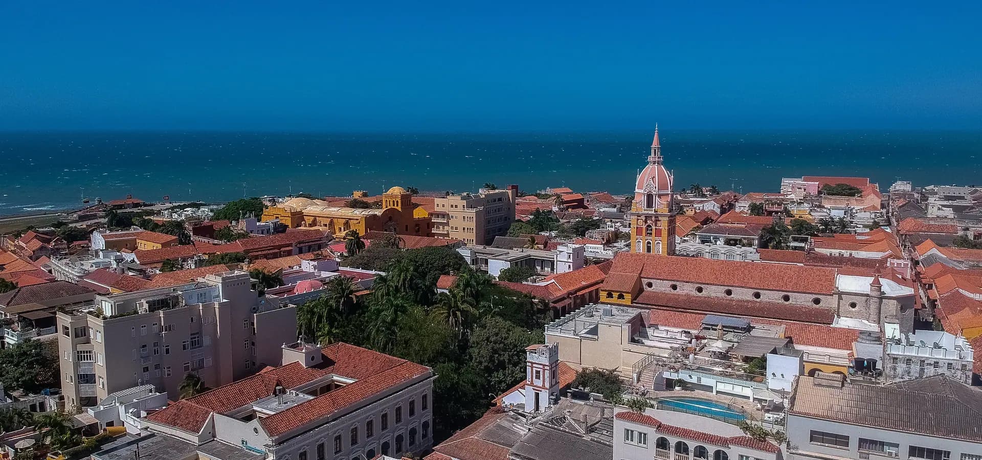Tejados de terracota del centro histórico de Cartagena y la torre de la catedral, con el Caribe azul al fondo